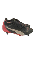 Puma black and red football boots with white formstripe, showing scuffing and wear.
