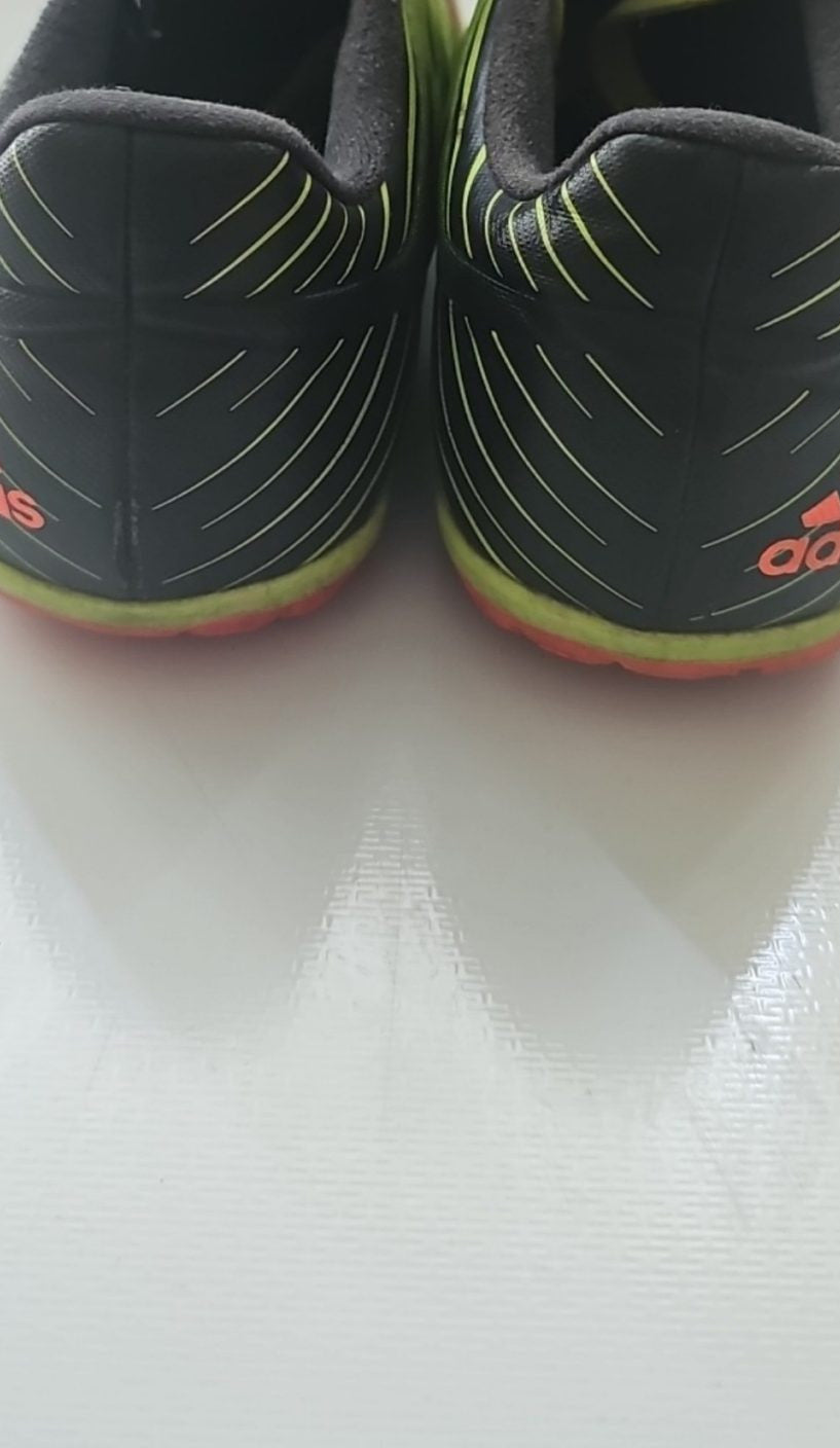 Adidas black and green soccer trainers with red accents, synthetic material, moderate wear.