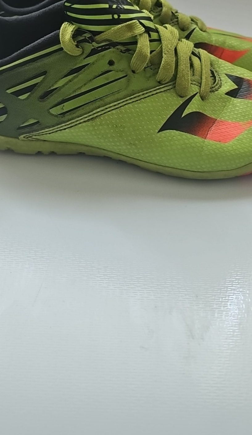 Adidas black and green soccer trainers with red accents, synthetic material, moderate wear.