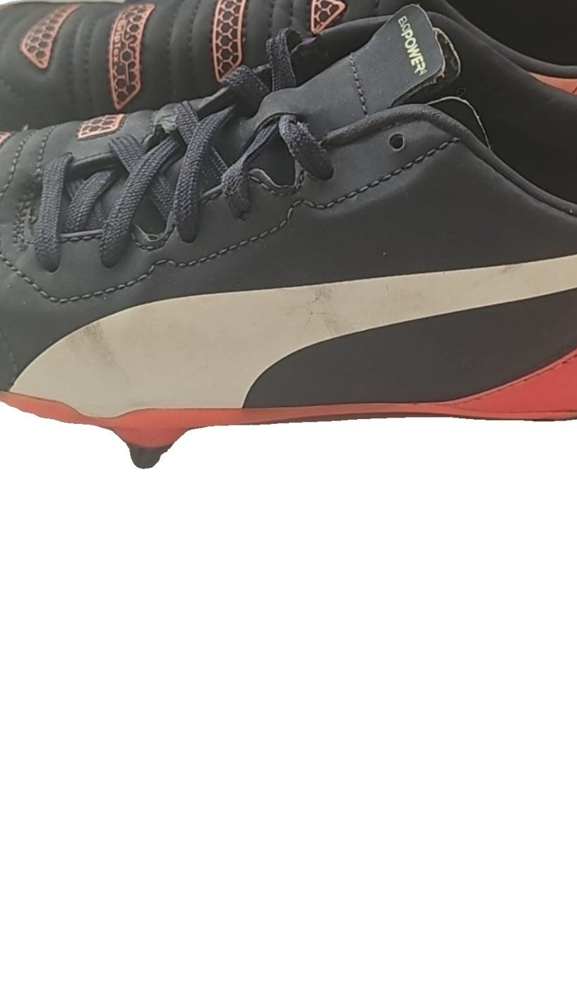 Puma black and red football boots with white formstripe, showing scuffing and wear.