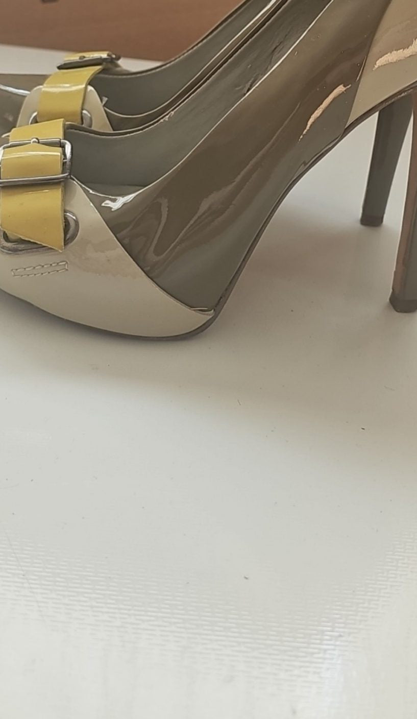 ALDO beige and taupe patent leather high heel shoes with yellow buckle detail.