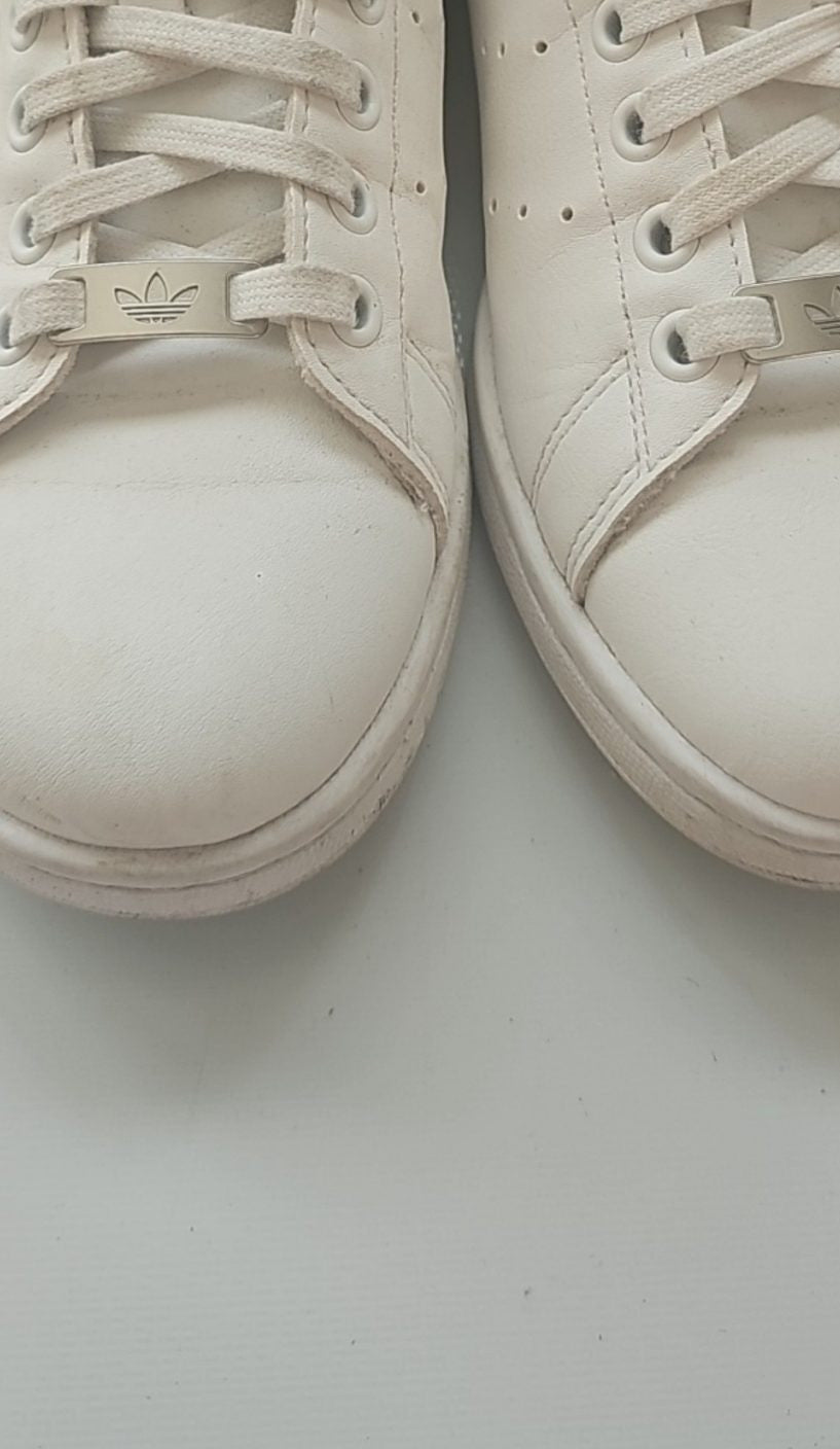 Adidas white Stan Smith sneakers with perforated three stripes and logo on tongue.