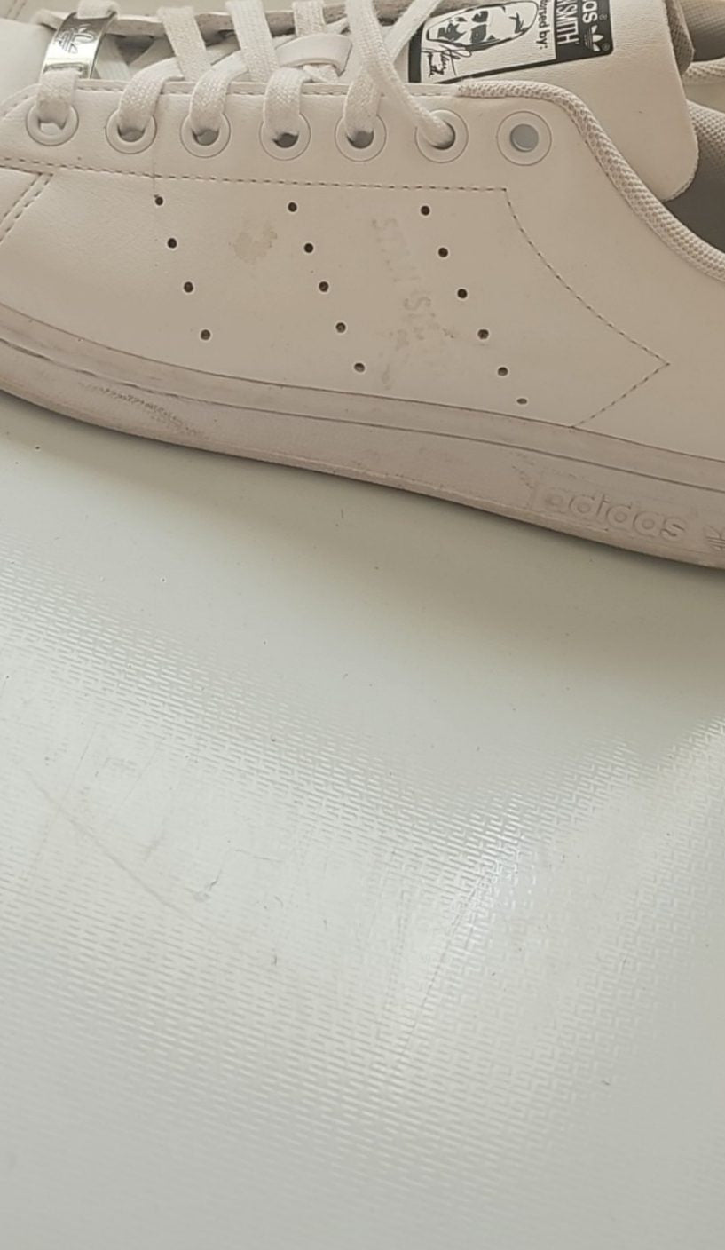 Adidas white Stan Smith sneakers with perforated three stripes and logo on tongue.