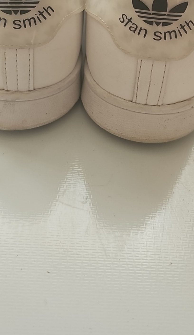 Adidas white Stan Smith sneakers with perforated three stripes and logo on tongue.
