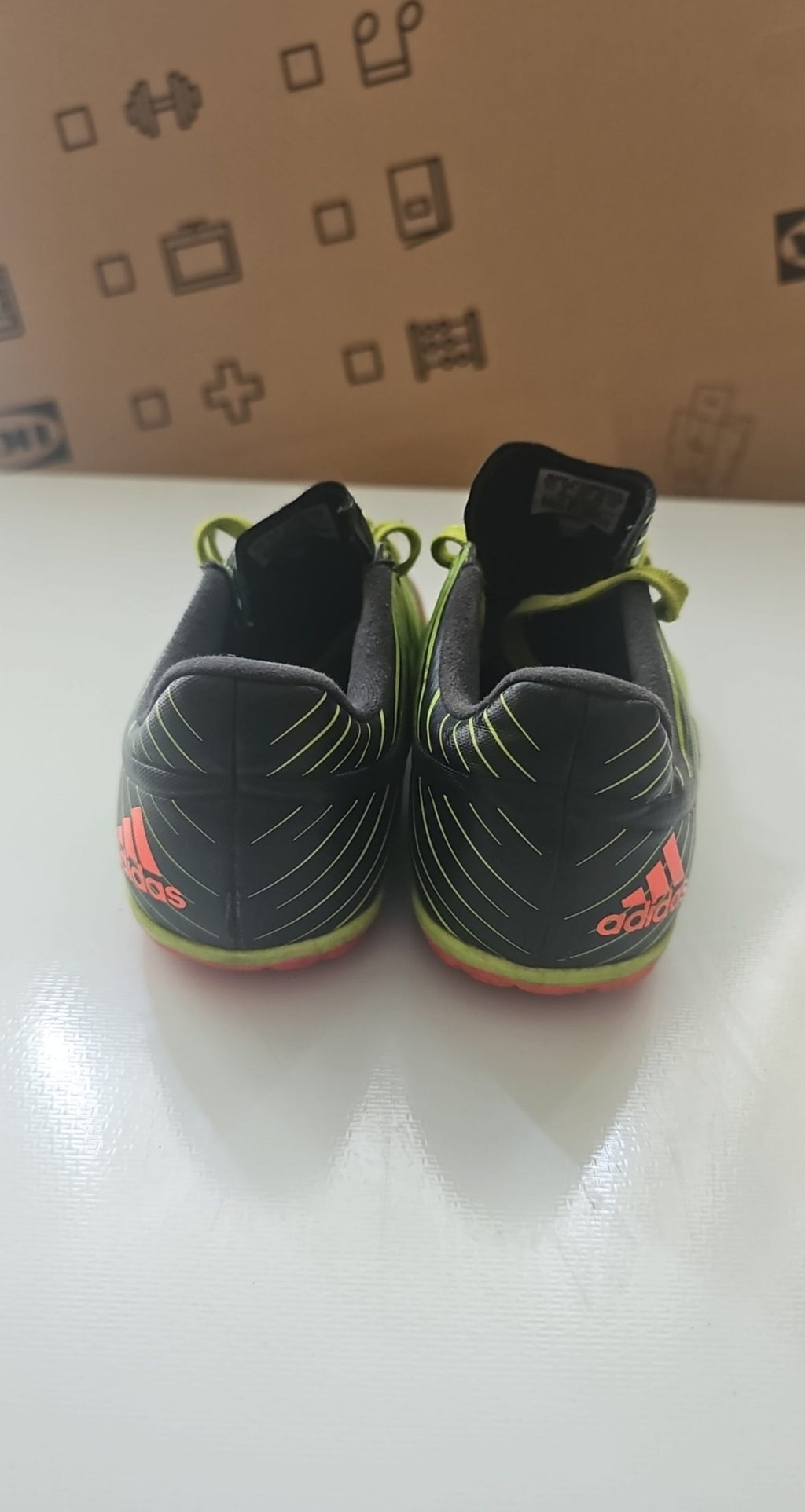 Adidas green and black soccer trainers with red accents, synthetic material, moderate wear.