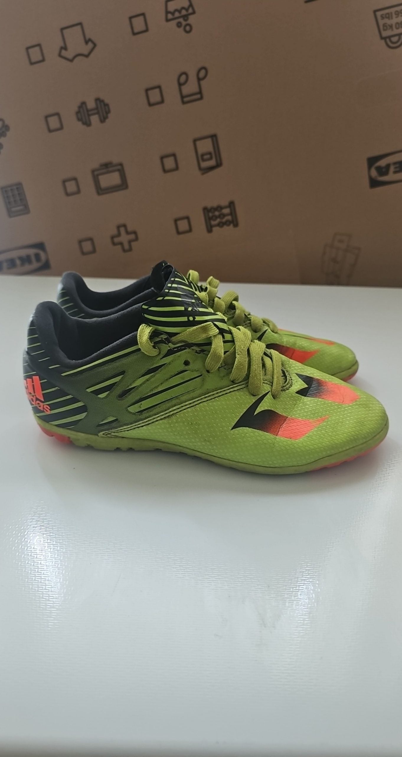 Adidas green and black soccer trainers with red accents, synthetic material, moderate wear.
