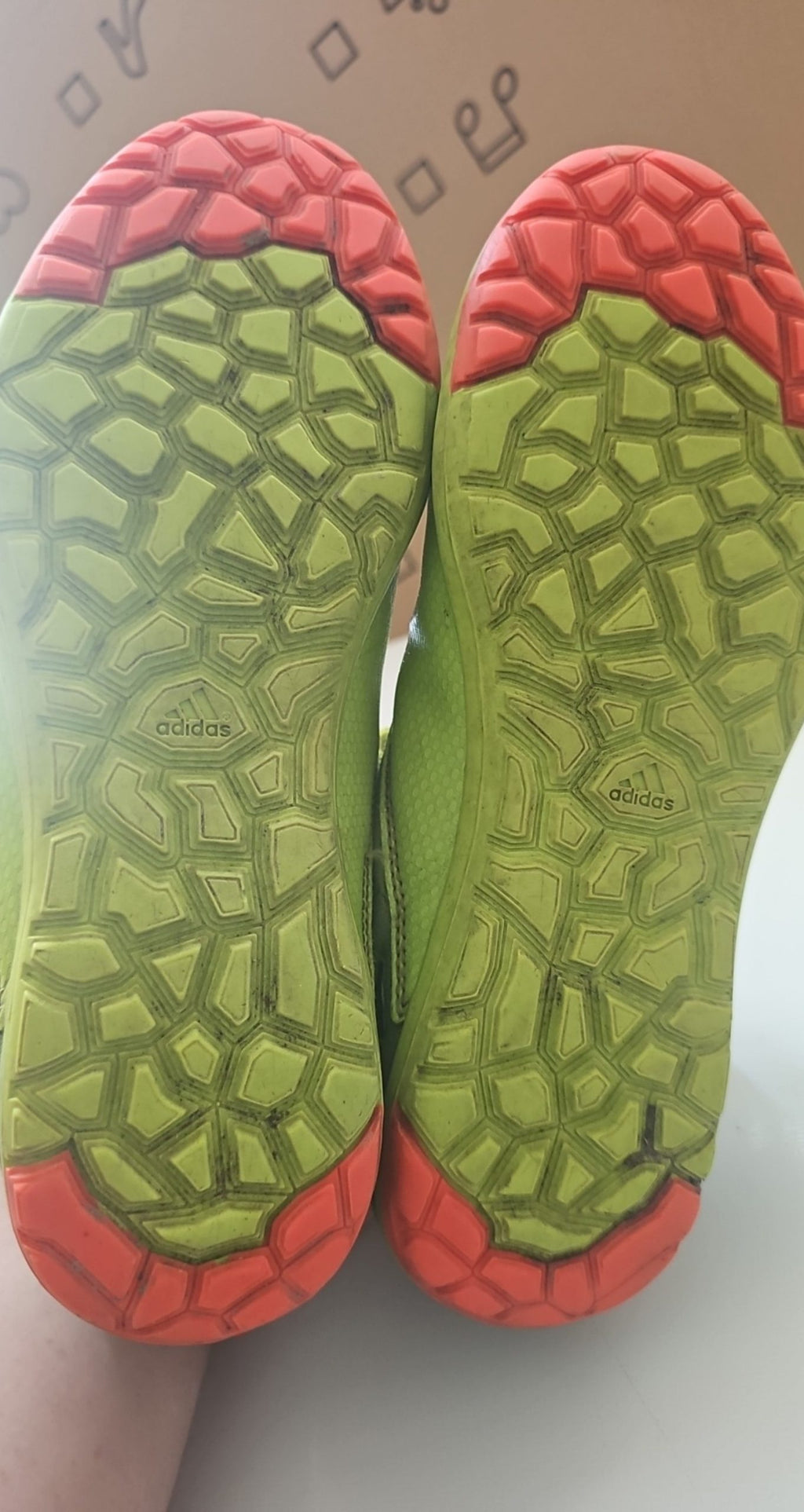 Adidas green and black soccer trainers with red accents, synthetic material, moderate wear.