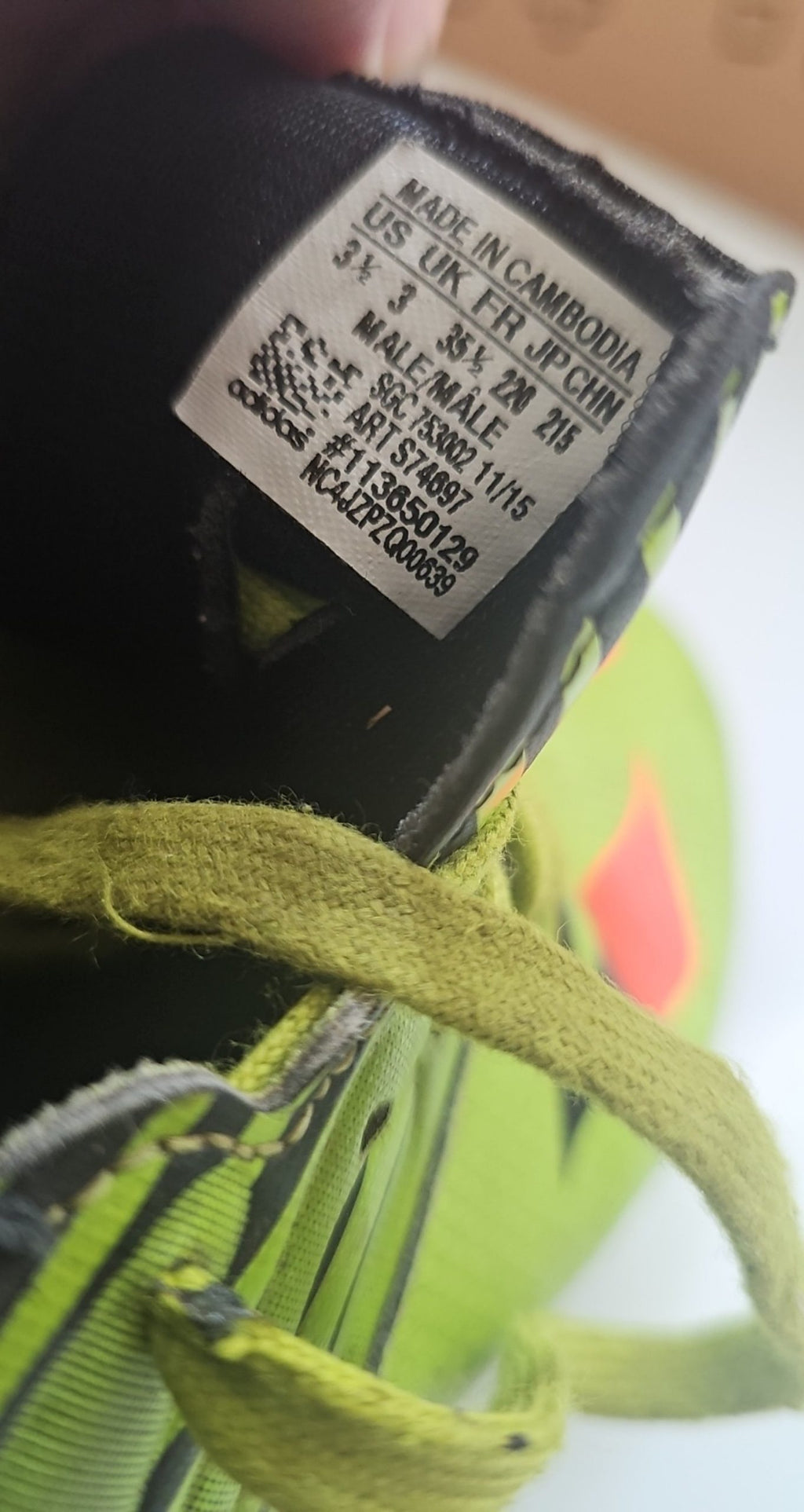 Adidas green and black soccer trainers with red accents, synthetic material, moderate wear.