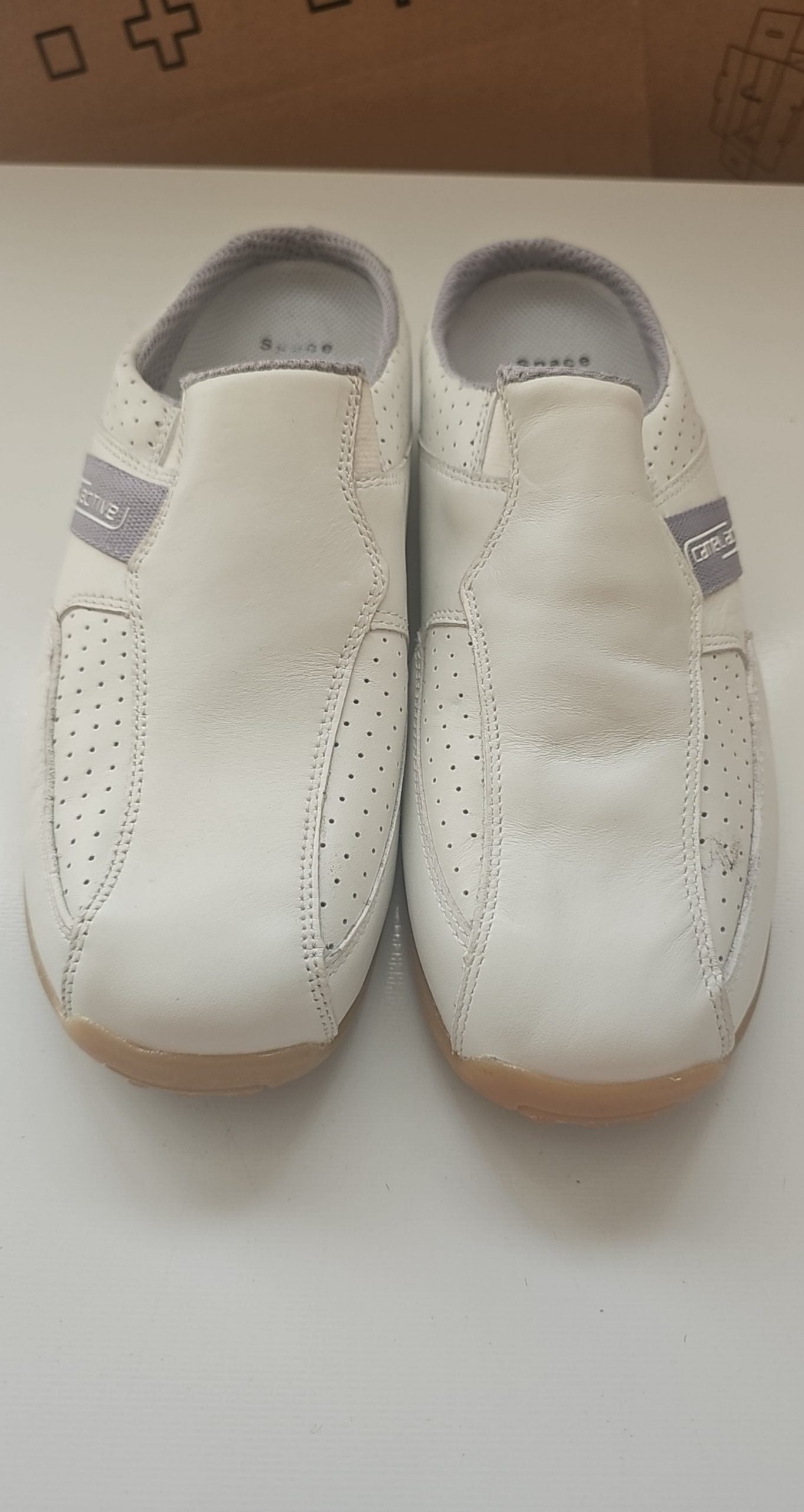 Camel Active grey and white leather slip-on shoes with perforated details and logo.