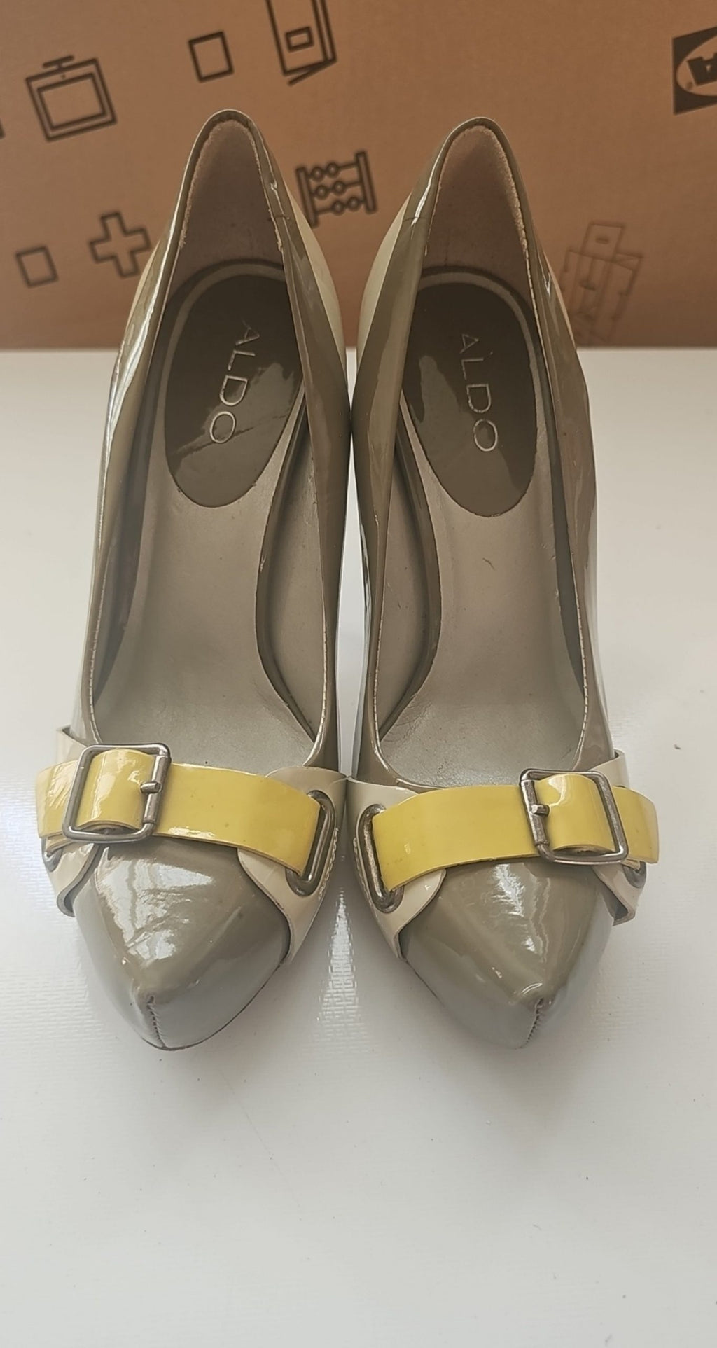 ALDO beige and taupe patent leather high heel shoes with yellow buckle detail.