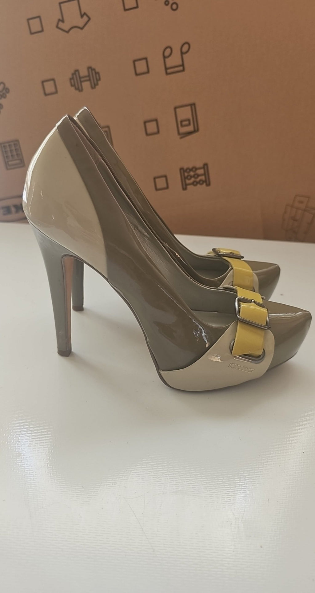 ALDO beige and taupe patent leather high heel shoes with yellow buckle detail.