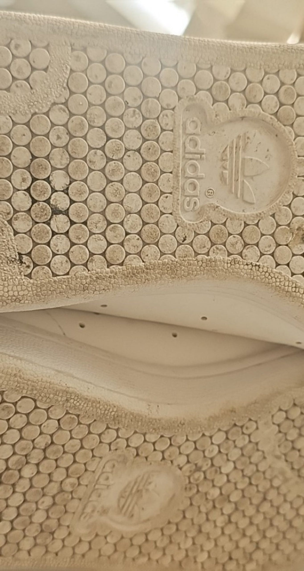 Adidas white Stan Smith sneakers with perforated three stripes and logo on tongue.